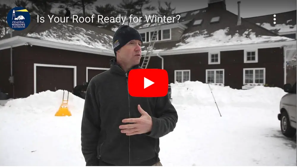 A man in winter clothing stands outside a snow-covered house with a ladder propped against the roof, ready to protect their home from winter. Snow piles surround the area. A YouTube play button overlays the image with text: Is Your Roof Ready for Winter?.